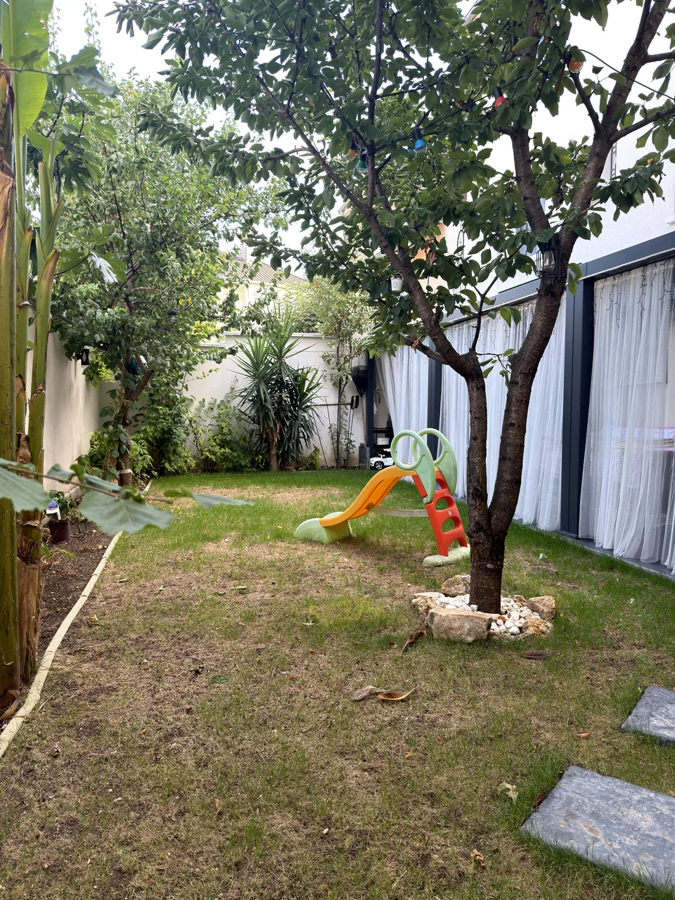 Jardin privé et sécurisé avec toboggan, chez Malika Temmar, assistante maternelle à Orly